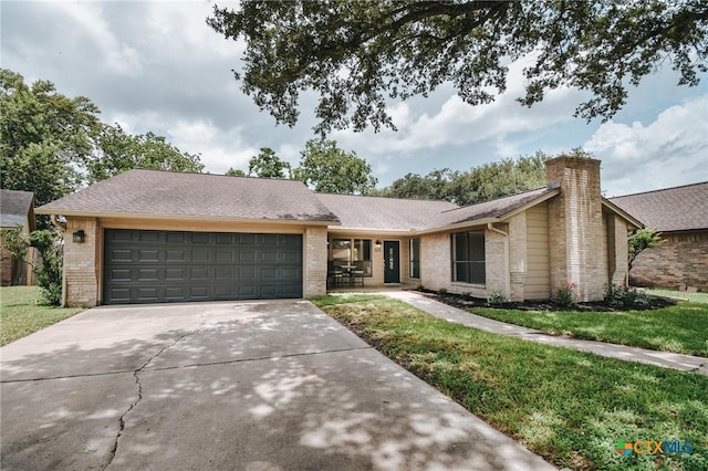 505 Bramble Bush Ln, Victoria, TX 77904 - mid-century modern home with brick siding, a garage, concrete driveway, a front lawn, and a chimney