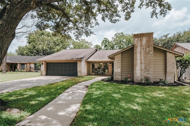 505 Bramble Bush Ln, Victoria, TX 77904 - mid-century modern home featuring brick siding, an attached garage, a front lawn, and concrete driveway
