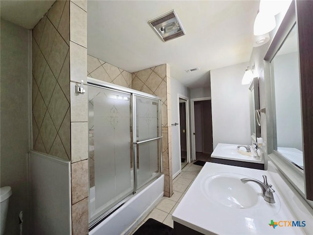 full bathroom featuring tile patterned flooring, vanity, toilet, and combined bath / shower with glass door