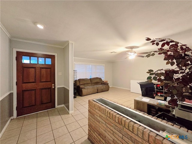 tiled entrance foyer with crown molding and ceiling fan