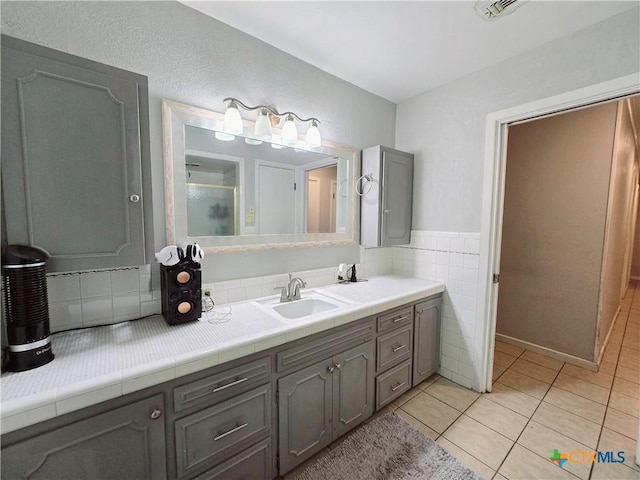 bathroom with vanity, tile patterned floors, and tile walls