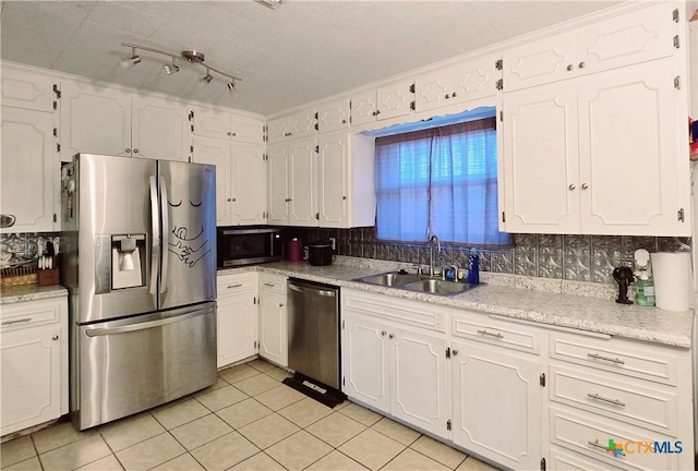 kitchen with stainless steel appliances, tasteful backsplash, sink, and white cabinets