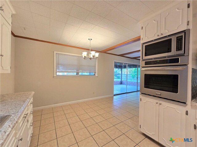 113 Apache Dr, Temple, TX 76504 - kitchen with appliances with stainless steel finishes, crown molding, white cabinetry, a chandelier, and light tile patterned floors