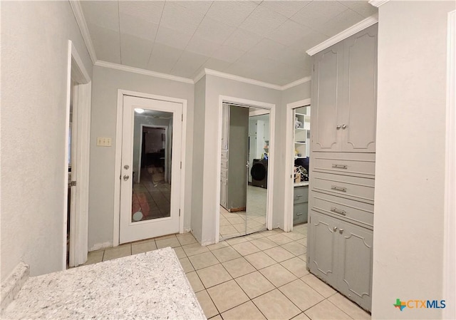 hall featuring ornamental molding, washer / dryer, and light tile patterned floors