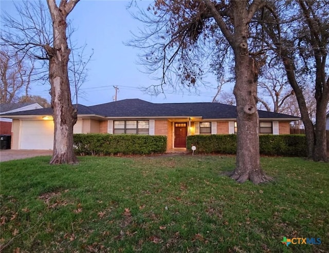 single story home with a garage and a front lawn