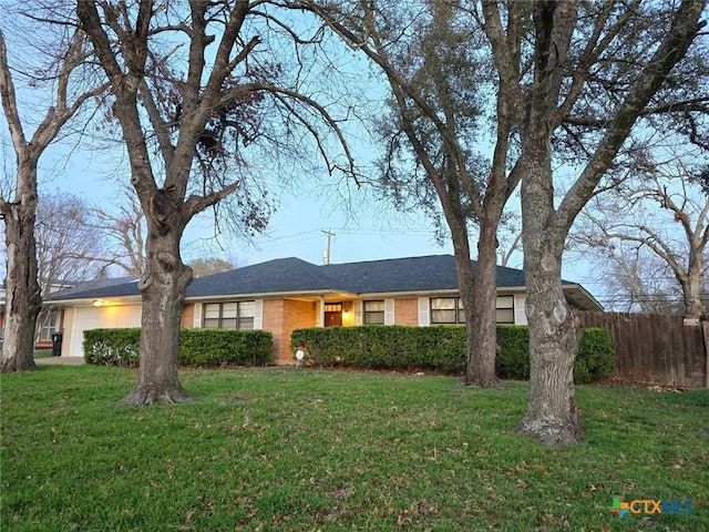 ranch-style home featuring a garage and a front yard