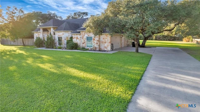 ranch-style house with stone siding, fence, concrete driveway, and a front yard