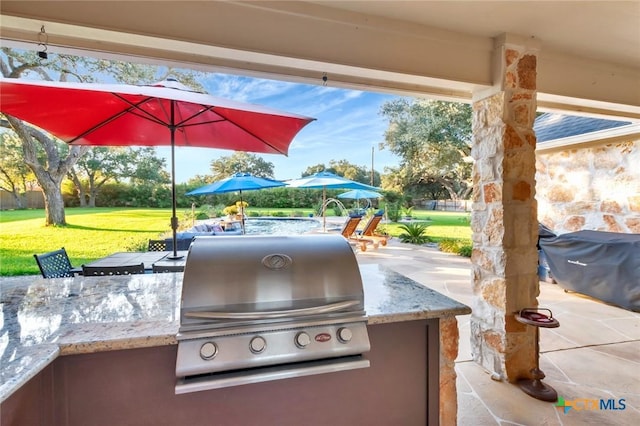 view of patio with grilling area and an outdoor kitchen