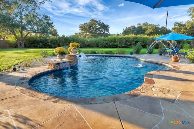 outdoor pool featuring a lawn and a patio area