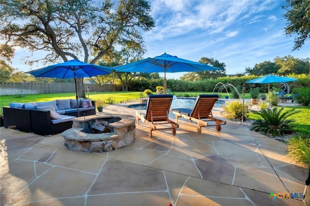 view of patio with an outdoor living space with a fire pit and fence