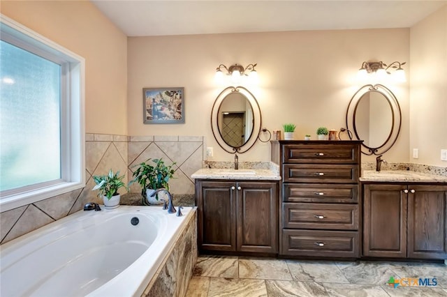 full bathroom featuring a garden tub, a sink, and double vanity