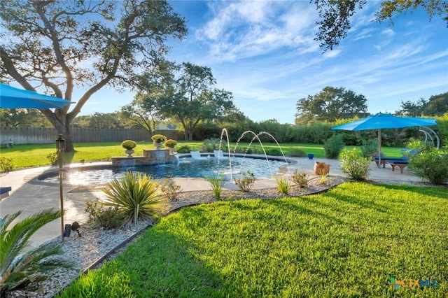 view of swimming pool featuring fence and a lawn