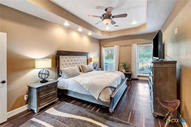 bedroom featuring visible vents, baseboards, a raised ceiling, dark wood-type flooring, and access to outside