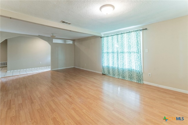 empty room with a textured ceiling, hardwood / wood-style flooring, and ceiling fan