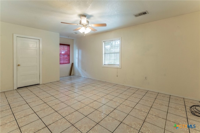 tiled spare room with ceiling fan