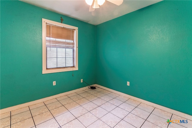 tiled spare room featuring ceiling fan