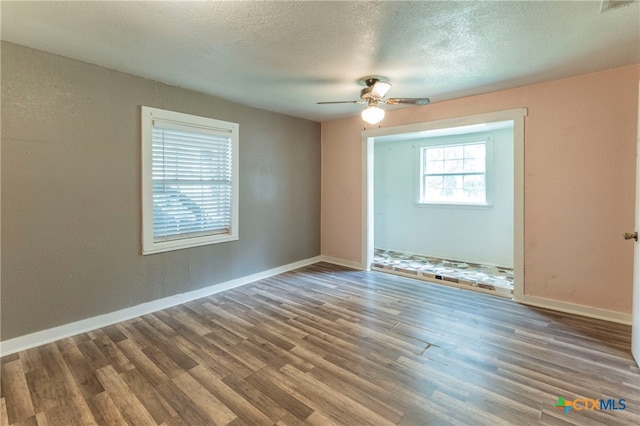 empty room with ceiling fan, a textured ceiling, and hardwood / wood-style flooring