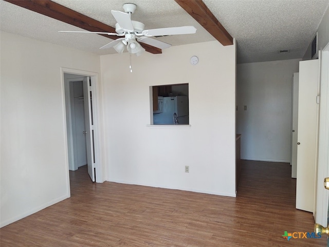 spare room featuring hardwood / wood-style floors, ceiling fan, beam ceiling, and a textured ceiling