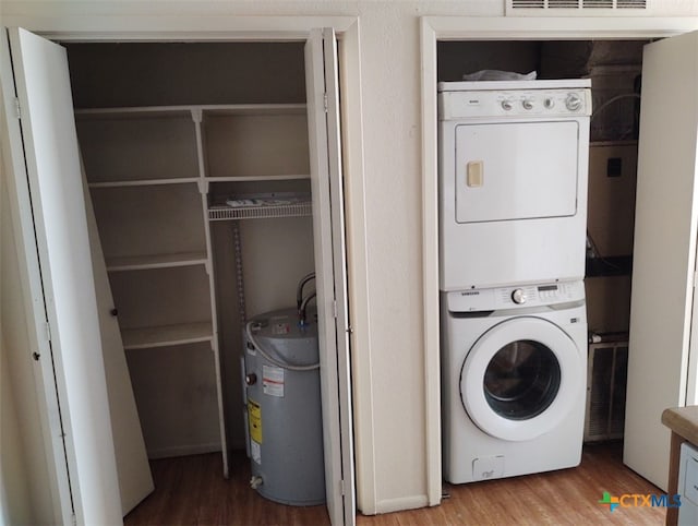 laundry room featuring electric water heater, stacked washer and dryer, and wood-type flooring