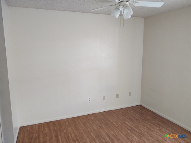 empty room featuring hardwood / wood-style floors, ceiling fan, and a textured ceiling