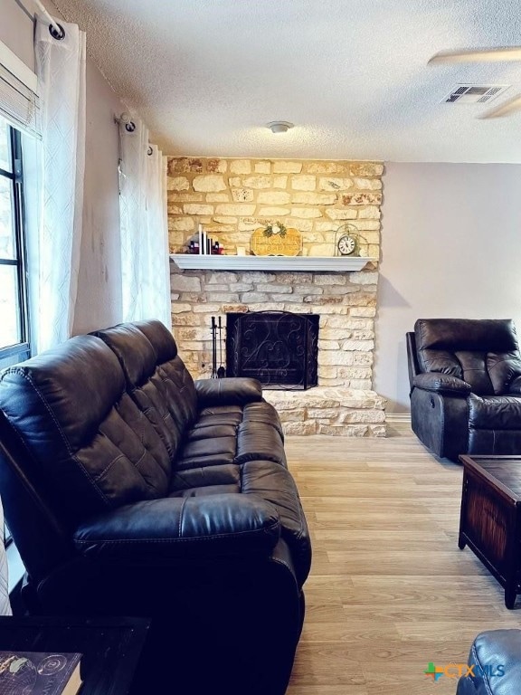 living room featuring hardwood / wood-style floors, a fireplace, and a textured ceiling