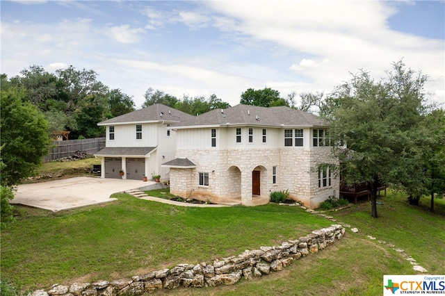 back of property with a garage and a yard