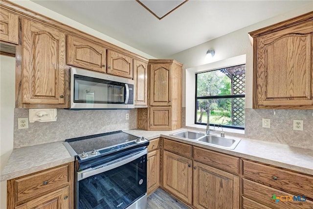 kitchen featuring tasteful backsplash, appliances with stainless steel finishes, and sink