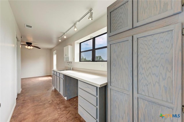 kitchen featuring sink, ceiling fan, gray cabinetry, track lighting, and concrete floors