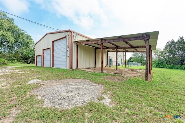 exterior space with a garage, a carport, and a lawn