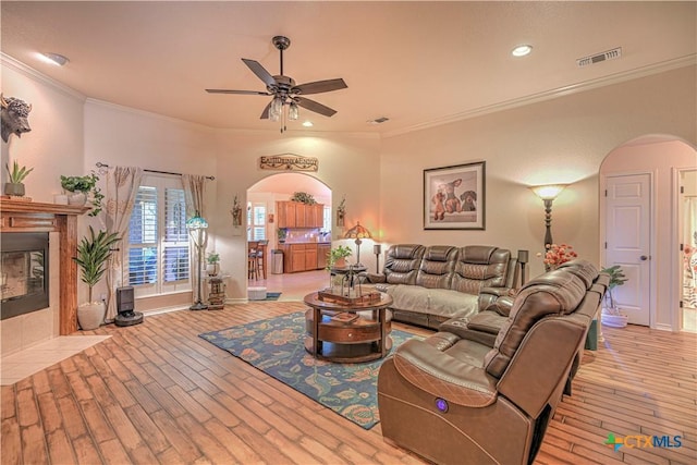 1521 Shadow Canyon Dr, Temple, TX 76502 - living room with arched walkways, wood finished floors, a ceiling fan, a fireplace, and ornamental molding