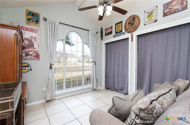 doorway to outside featuring ceiling fan, light tile patterned floors, a wealth of natural light, and vaulted ceiling with beams