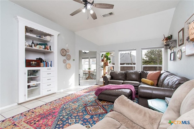 living room featuring vaulted ceiling, light tile patterned floors, and a healthy amount of sunlight