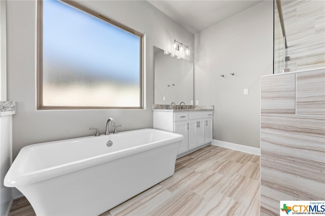 bathroom featuring a tub to relax in and vanity