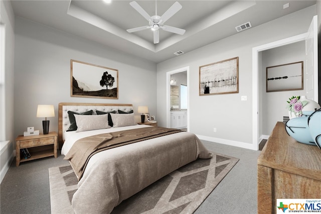 bedroom featuring carpet, a raised ceiling, ceiling fan, and ensuite bathroom