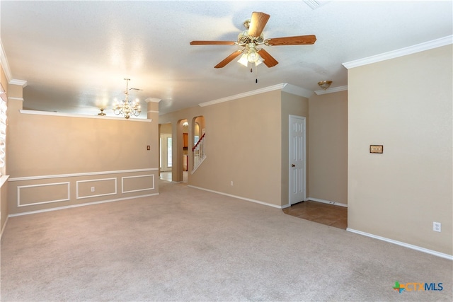 carpeted spare room with ceiling fan with notable chandelier and ornamental molding