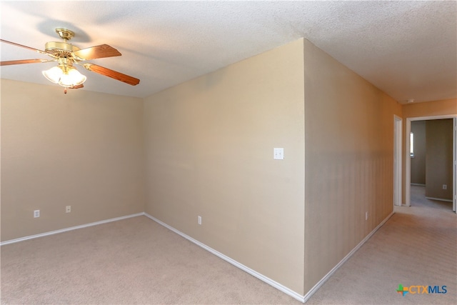 carpeted spare room featuring a textured ceiling and ceiling fan