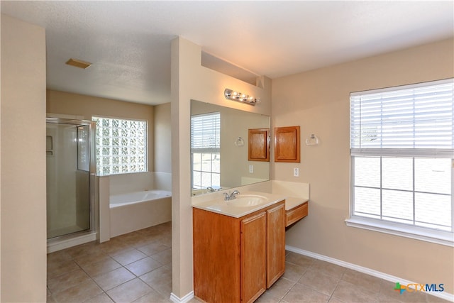 bathroom featuring independent shower and bath, tile patterned flooring, and a healthy amount of sunlight