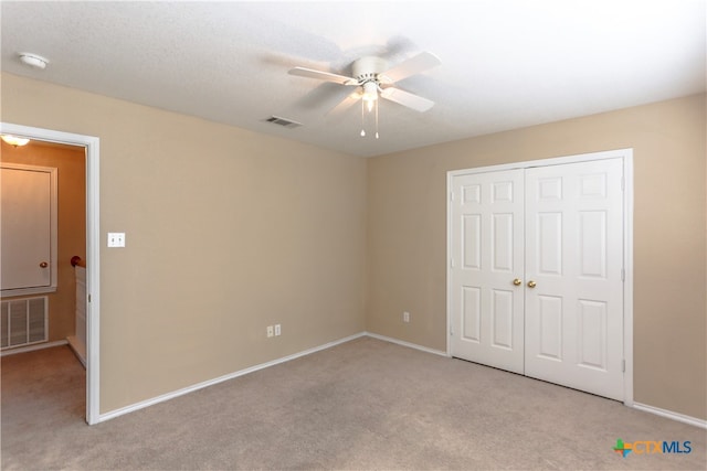 unfurnished bedroom with light carpet, ceiling fan, and a closet