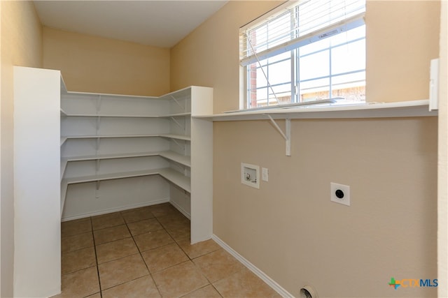 interior space with washer hookup, hookup for an electric dryer, and light tile patterned flooring