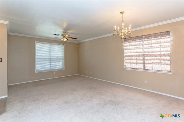 carpeted spare room featuring ceiling fan with notable chandelier and ornamental molding