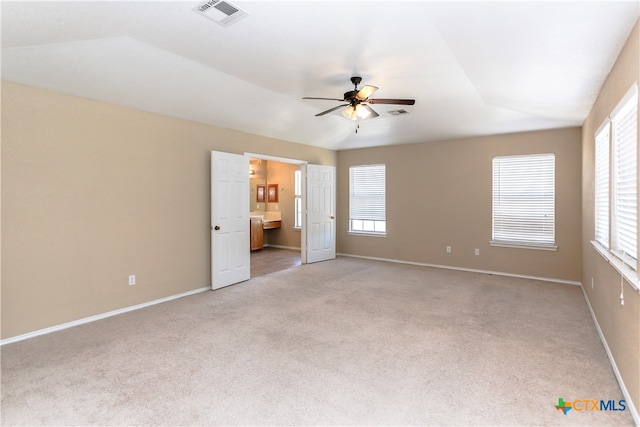 unfurnished bedroom featuring ensuite bathroom, light carpet, ceiling fan, and lofted ceiling