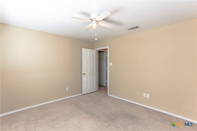 carpeted spare room featuring ceiling fan