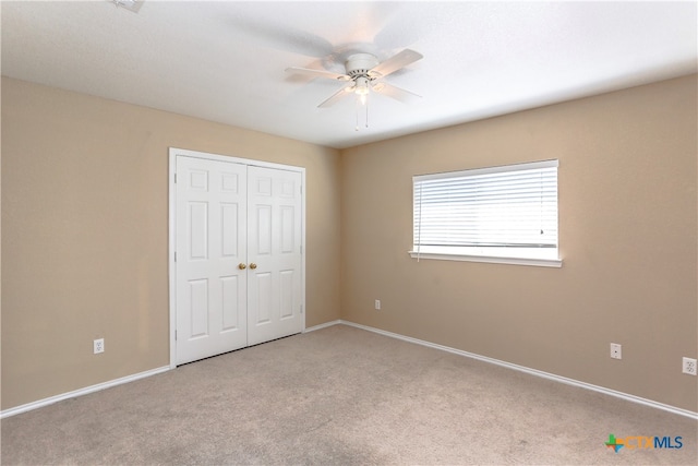 unfurnished bedroom featuring a closet, light colored carpet, and ceiling fan