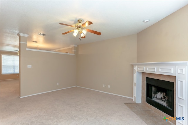 unfurnished living room with ceiling fan, a tile fireplace, a textured ceiling, and light colored carpet