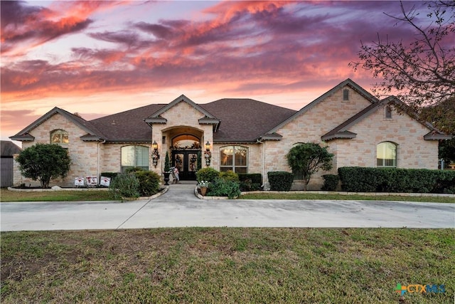 french country inspired facade with french doors and a yard