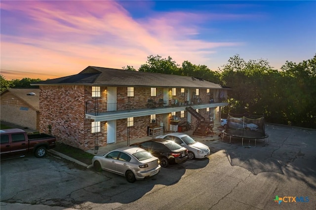 1203 Urbantke Ct Unit A-H, Copperas Cove, TX 76522 - view of property with a trampoline, stairs, brick siding, uncovered parking, and a balcony