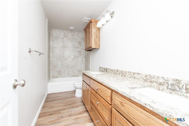 full bathroom featuring hardwood / wood-style floors, vanity, toilet, and shower / bathtub combination