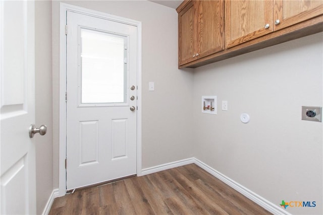 washroom featuring electric dryer hookup, cabinets, dark wood-type flooring, and washer hookup