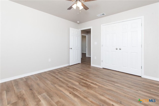 unfurnished bedroom with light wood-type flooring, a closet, and ceiling fan