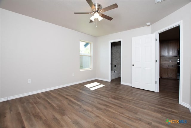 unfurnished bedroom featuring ensuite bathroom, ceiling fan, and dark wood-type flooring